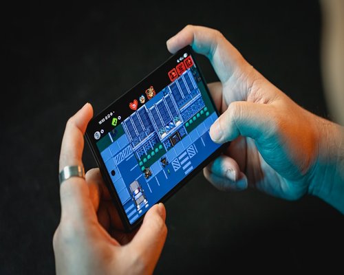 Smartphone displaying a fictional mobile game during a BaseNimbusCrown Australian gaming technology exhibition