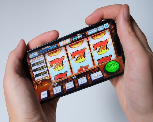 Smartphone with a fictional beginner-friendly game screen displayed during a gaming exhibition